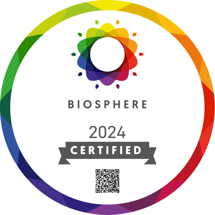 Un badge circulaire avec une bordure arc-en-ciel, une fleur abstraite multicolore, le mot 